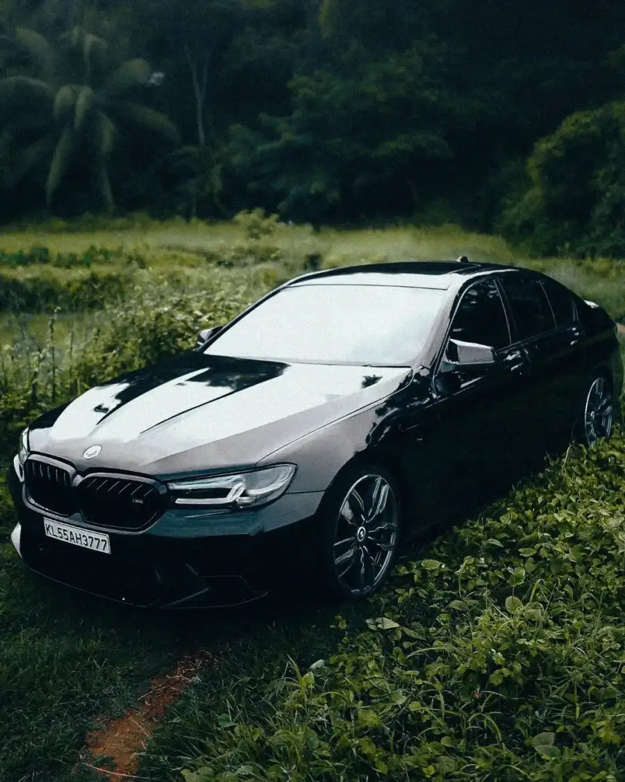 CB Black Car Parked On A Dirt Road With Trees In The Background