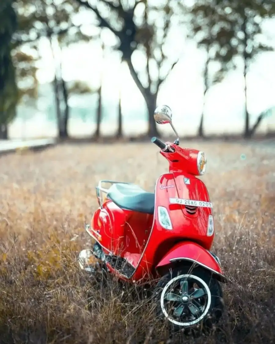 CB Red Red Scooter Parked In A Field Background