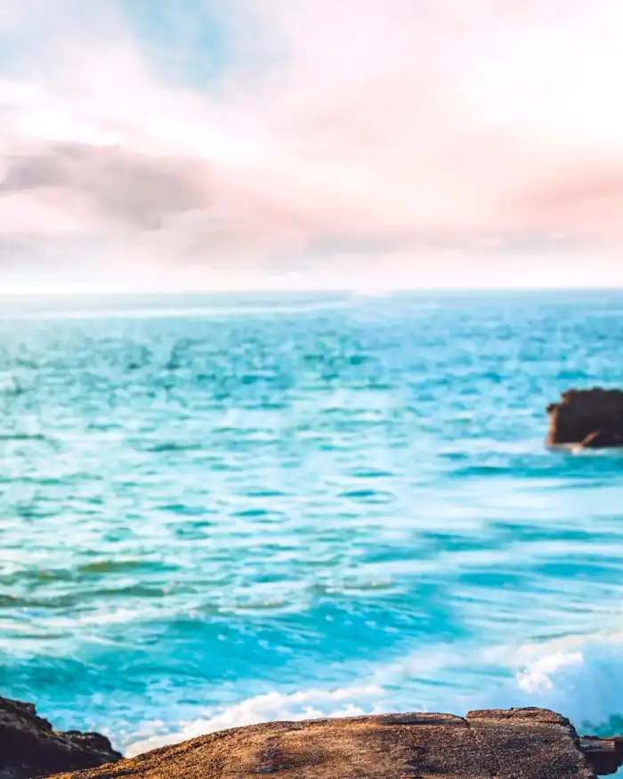 Photo Editing Body Of Water With Rocks And A Cloudy Sky Background