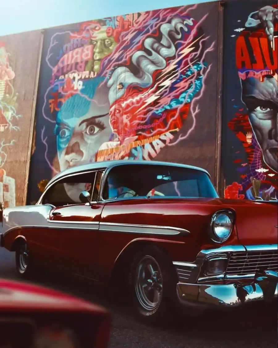 Photo Editing Red Car Parked In Front Of A Wall With Art Background